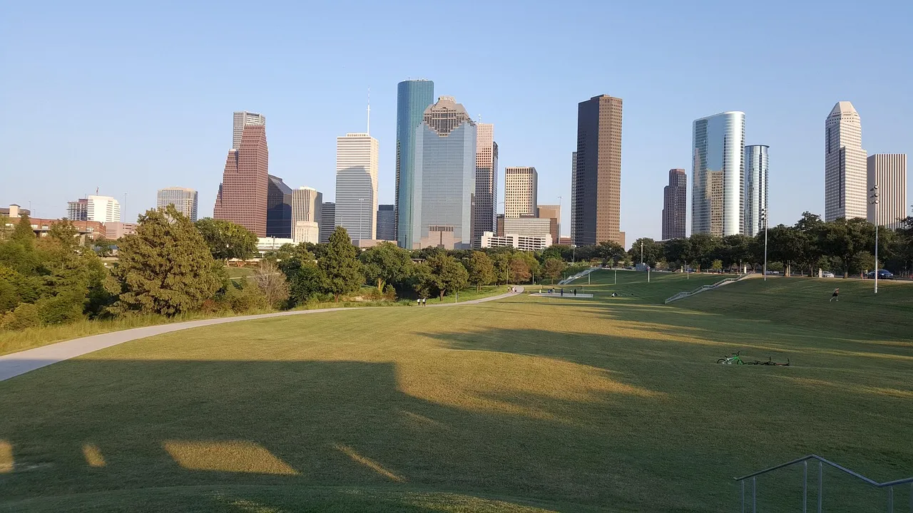 Downtown Houston's skyline seen across the lawns of Buffalo Bayou Park on a clear evening