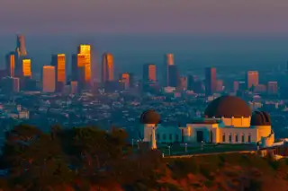 Griffith Observatory at sunset with the downtown Los Angeles towers behind it