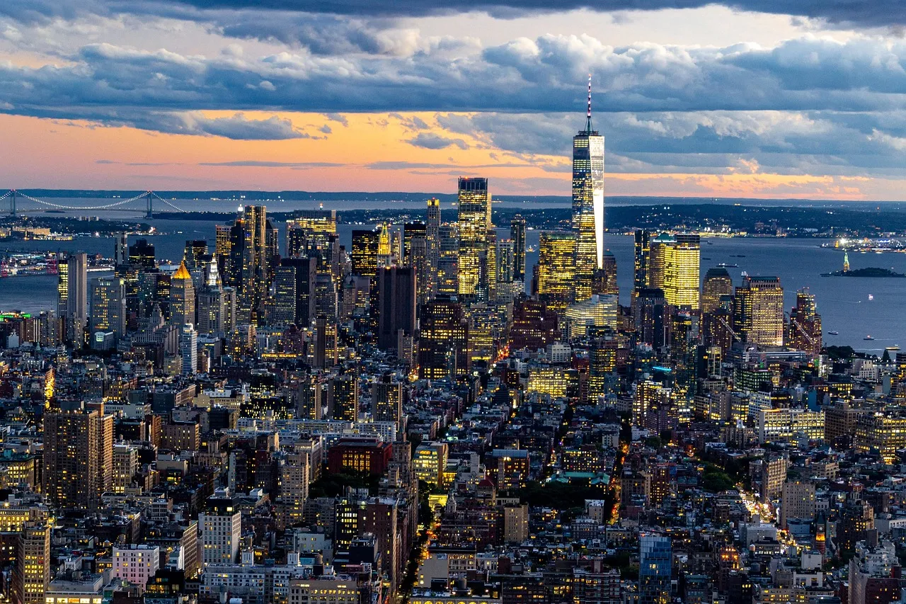 Lower Manhattan from above at dusk, with One World Trade Center and the harbour behind