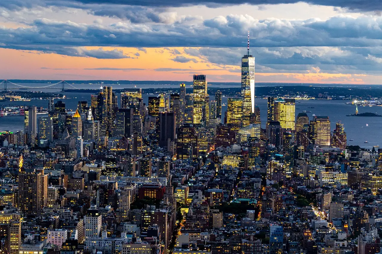 Lower Manhattan from above at dusk, with One World Trade Center and the harbour behind