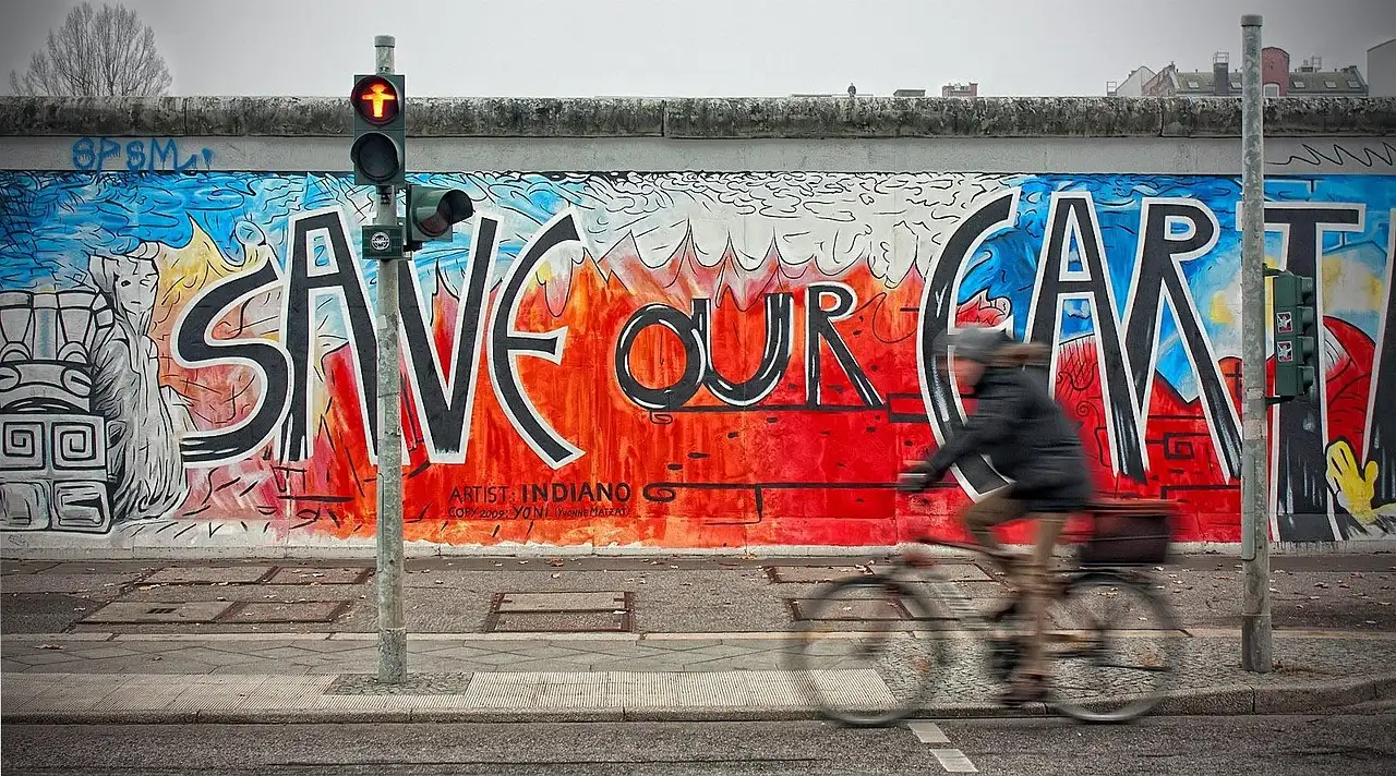 Ein Radfahrer an einem bemalten Stück der Berliner Mauer