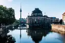 Das Bode-Museum auf der Museumsinsel spiegelt sich im Fluss, dahinter der Fernsehturm