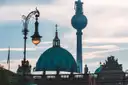 Die grüne Kuppel des Berliner Doms und der Fernsehturm hinter einer alten Straßenlaterne
