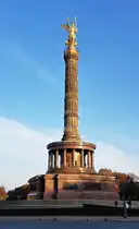 Die Siegessäule in Berlin mit ihrer goldenen Figur vor blauem Himmel