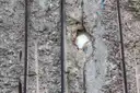 Ein verwittertes Stück der Berliner Mauer mit freiliegenden Stahlstäben