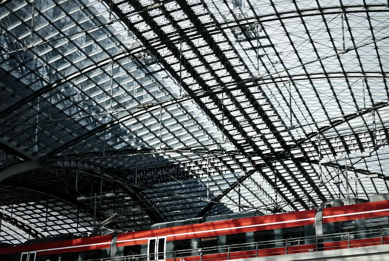 Ein roter Regionalzug unter dem riesigen Glas- und Stahldach des Berliner Hauptbahnhofs