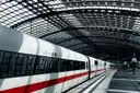 Ein weißer ICE mit rotem Streifen steht unter dem Glasdach des Berliner Hauptbahnhofs
