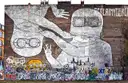 Ein riesiges Schwarz-Weiß-Wandbild einer Figur mit Schutzbrille an einer Backsteinwand in Kreuzberg