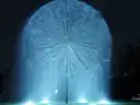 Ein beleuchteter Brunnen in Form einer riesigen Pusteblume bei Nacht in Houston