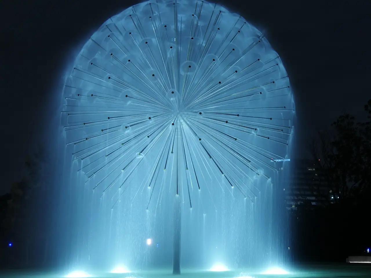 Ein beleuchteter Brunnen in Form einer riesigen Pusteblume bei Nacht in Houston