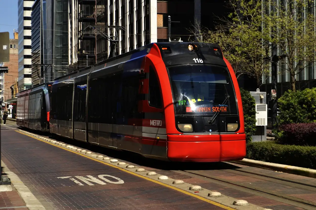 Eine rote Stadtbahn von METRORail auf einer Straße in Downtown Houston zwischen hohen Gebäuden