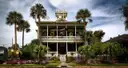 Ein historisches Haus mit breiter Veranda und Palmen in Galveston