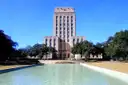 Das Rathaus von Houston, ein heller Steinturm, hinter seinem langen Wasserbecken an einem sonnigen Tag