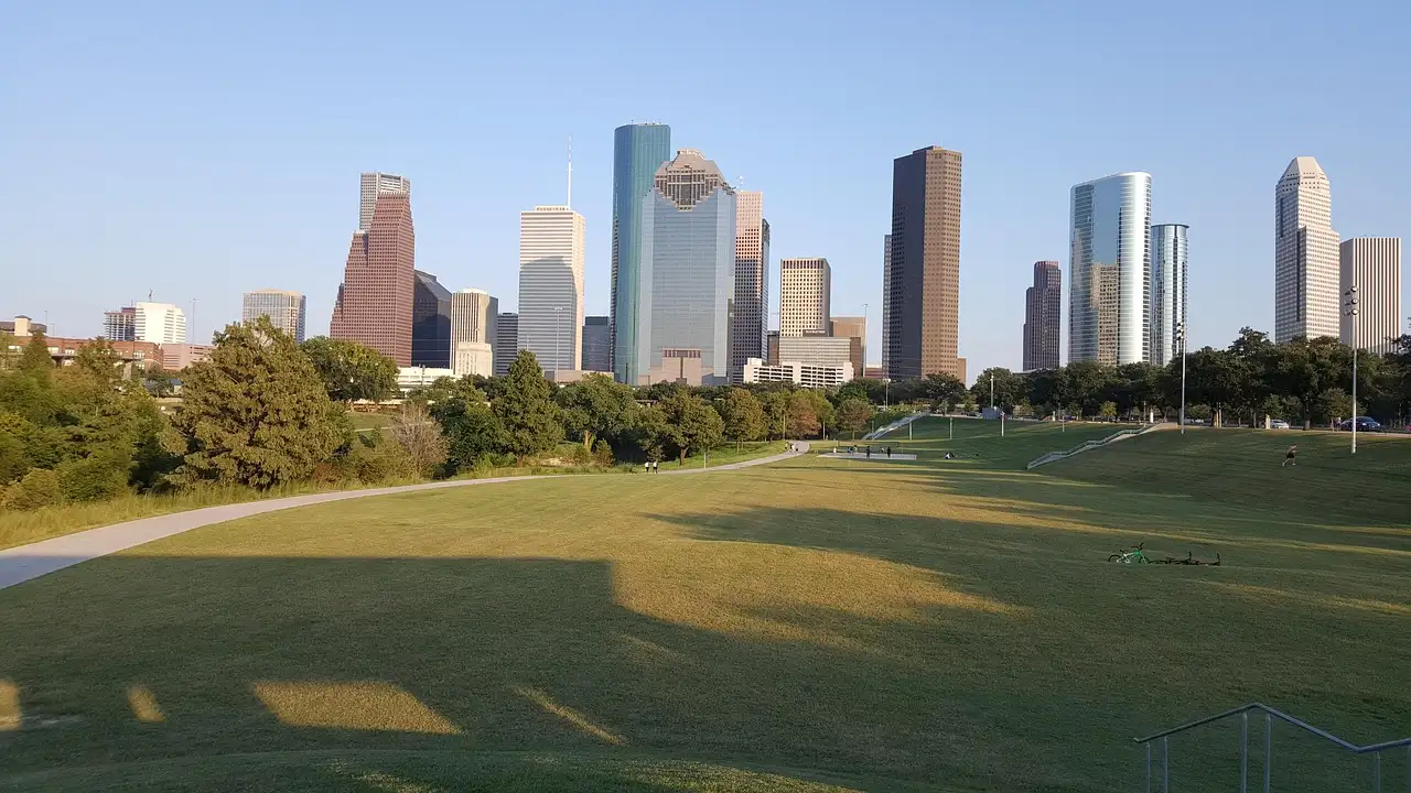 Die Skyline von Downtown Houston, gesehen über die Wiesen des Buffalo Bayou Park an einem klaren Abend