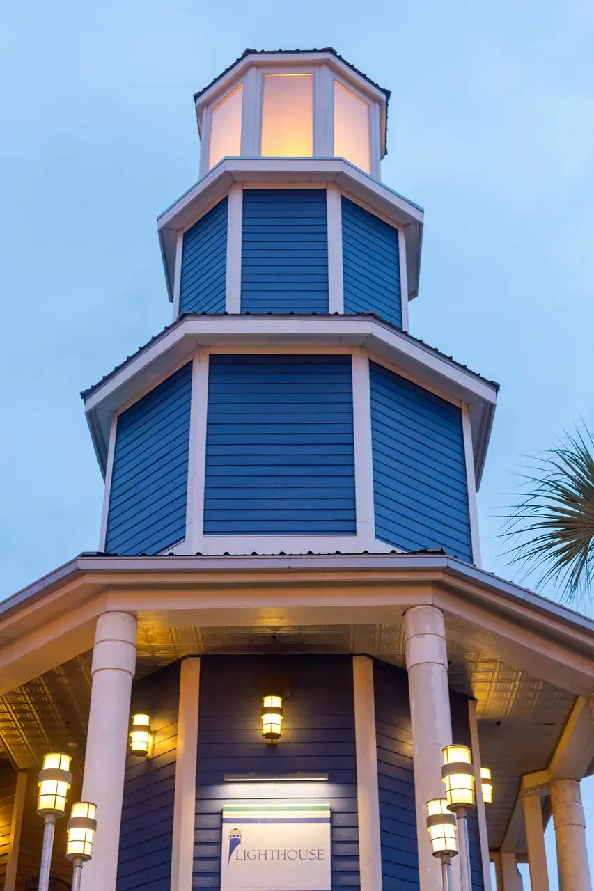 Ein blauer Leuchtturm aus Holz, beleuchtet in der Dämmerung an der Uferpromenade von Kemah am Clear Lake