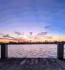 Ein Holzsteg am Wasser in Galveston unter einem bunten Abendhimmel