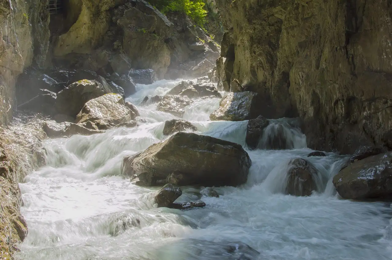 Weißes Wasser schießt in einer engen Schlucht über Felsen