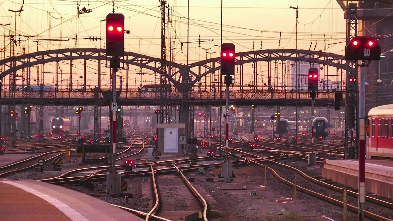 Signale und Gleise vor dem Münchner Hauptbahnhof in der Dämmerung, dahinter die Hackerbrücke