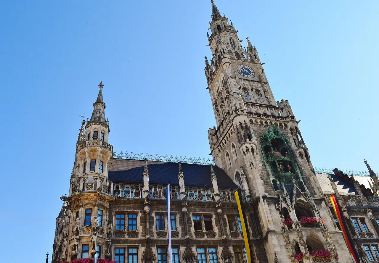 Der gotische Turm des Neuen Rathauses am Marienplatz von unten vor blauem Himmel