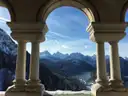 Ein Bergsee und verschneite Gipfel, durch Steinbögen gesehen