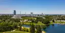 Das Stadion mit Zeltdach und der See im Münchner Olympiapark von oben an einem klaren Tag