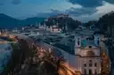 Salzburg in der Dämmerung mit dem Fluss, Kirchtürmen und der Festung auf dem Hügel