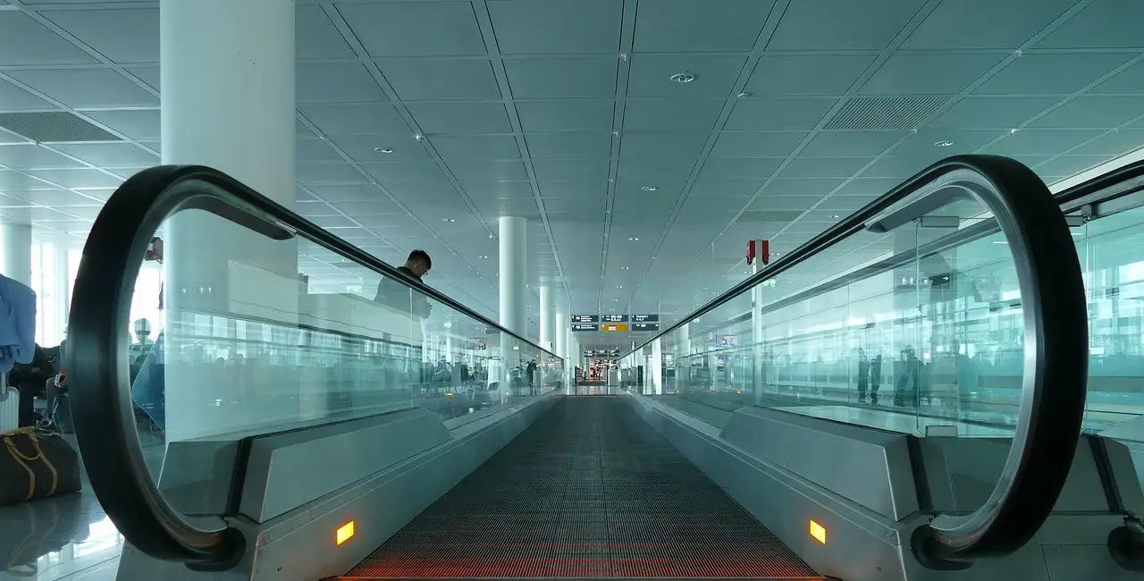 Ein Laufband in einer hellen Terminalhalle am Münchner Flughafen