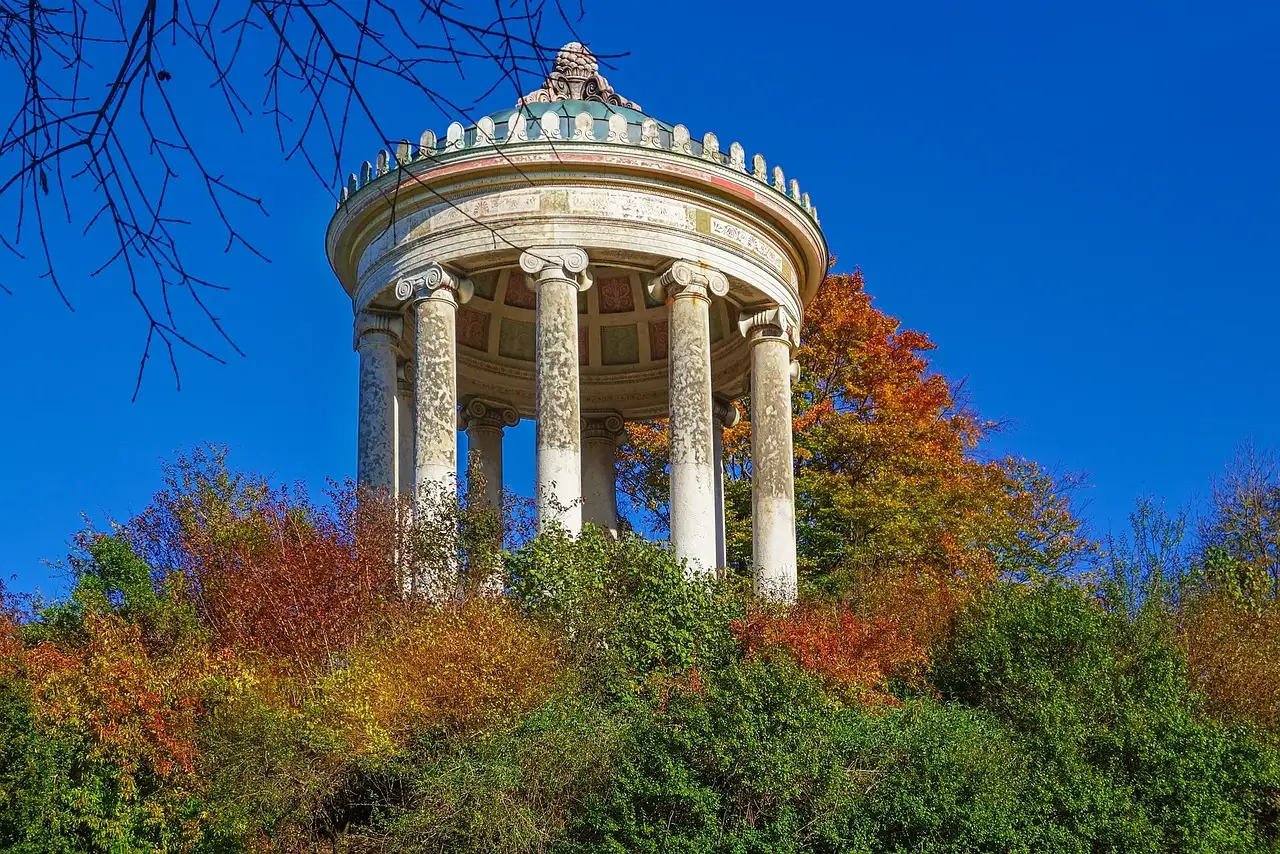 Der runde Monopteros zwischen Herbstbäumen im Englischen Garten in München
