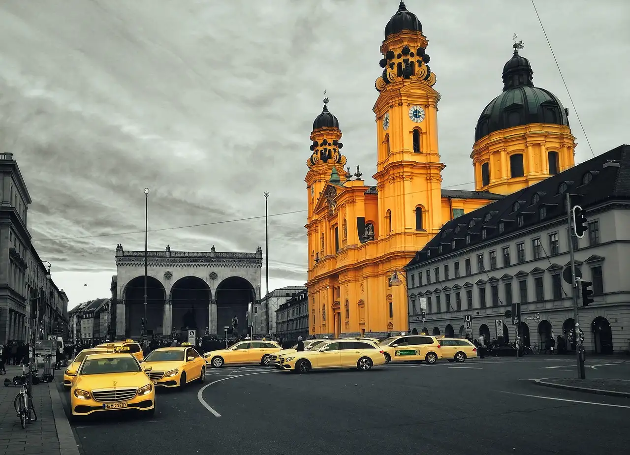 Der Odeonsplatz mit Feldherrnhalle und Theatinerkirche hinter einer Reihe Taxis