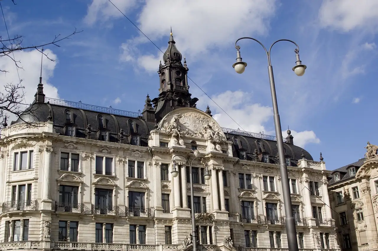 Eine Straßenlaterne vor einem verzierten historischen Gebäude in der Münchner Innenstadt an einem sonnigen Tag