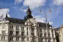 Eine Straßenlaterne vor einem verzierten historischen Gebäude in der Münchner Innenstadt an einem sonnigen Tag