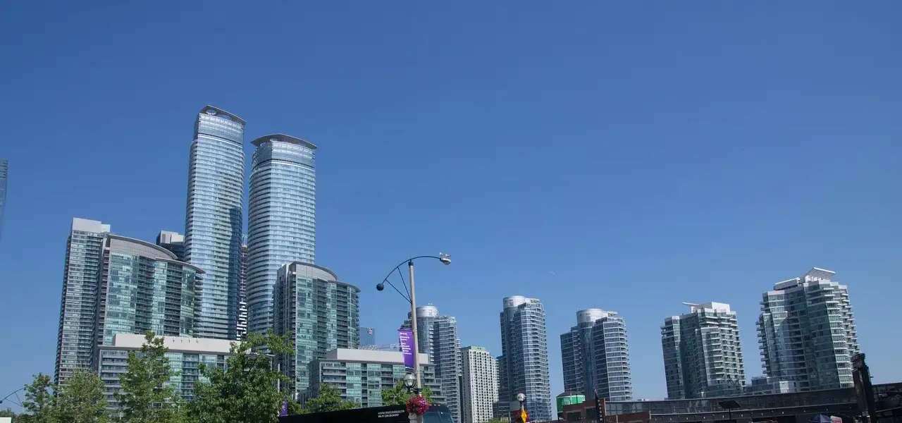 Gläserne Wohntürme am Queens Quay an Torontos Waterfront unter klarem blauem Himmel