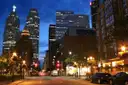 Eine Straße in Downtown Toronto in der Dämmerung, mit erleuchteten Bürotürmen und Straßenlaternen