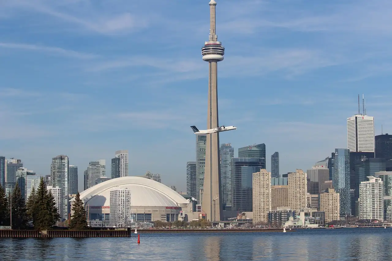 Der CN Tower und das Kuppelstadion daneben, an einem sonnigen Tag über das Wasser gesehen
