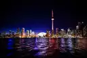 Torontos Skyline und der CN Tower nachts beleuchtet, gespiegelt im See