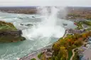 Die Horseshoe Falls im Herbst von oben, mit orangefarbenen Bäumen und einer Straße am Fluss