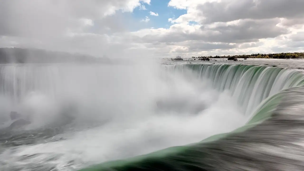 Grünes Wasser stürzt über die geschwungene Kante der Horseshoe Falls in die Gischt