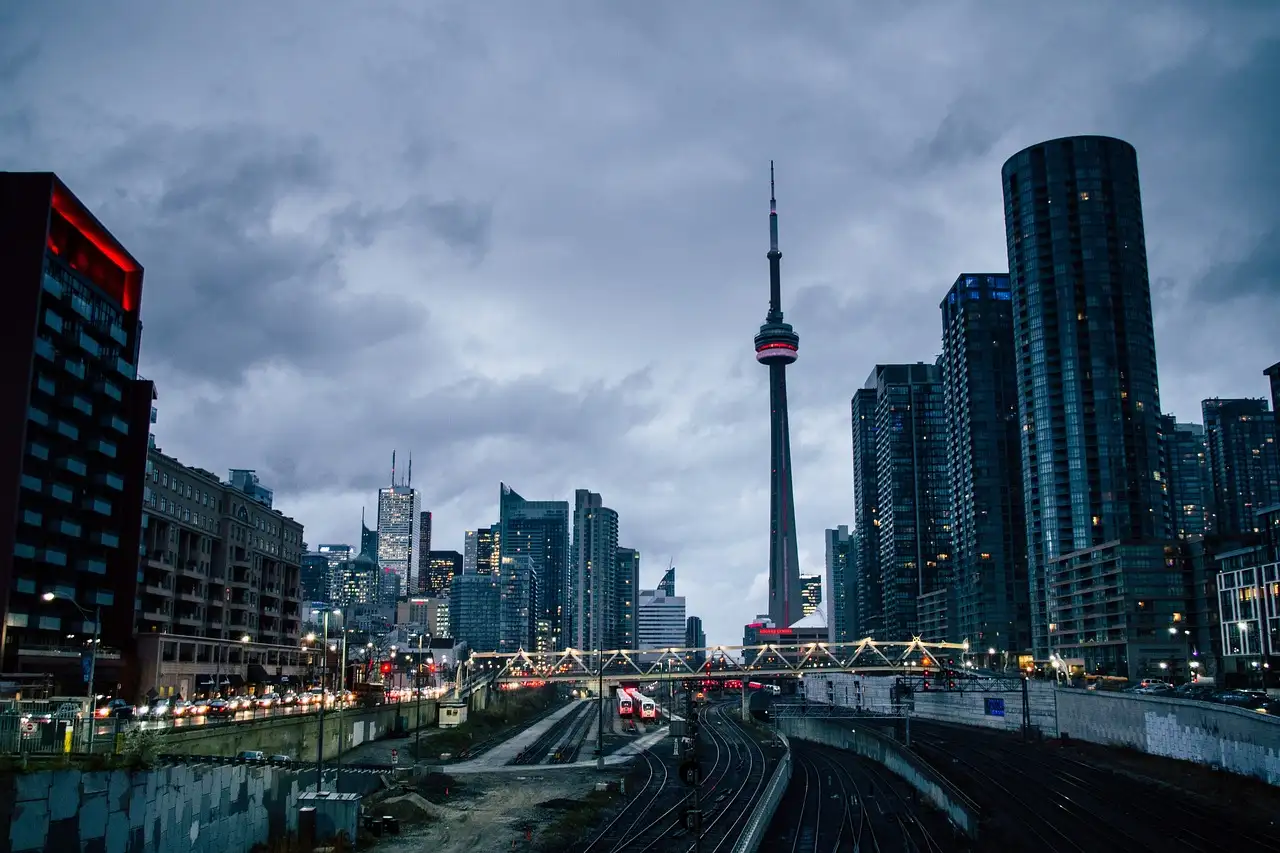 Bahngleise führen in der Dämmerung nach Downtown Toronto, vorn der CN Tower