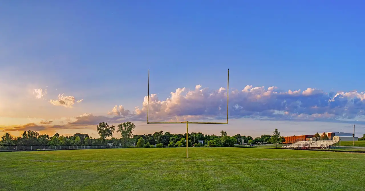 Ein Football-Torpfosten auf einem grünen Feld unter blauem Abendhimmel