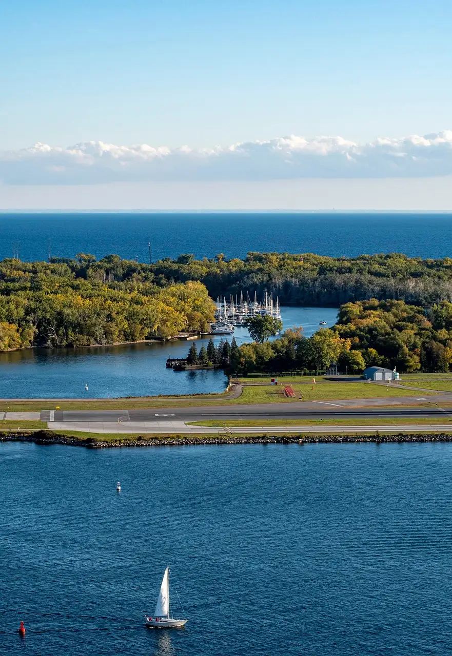 Luftbild der bewaldeten Toronto Islands, mit einem Segelboot im Hafen