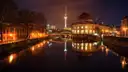 El Bode-Museum de la Isla de los Museos iluminado de noche, con la torre de televisión reflejada en el Spree