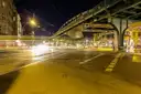 Un viaducto elevado del U-Bahn sobre un cruce tranquilo de Berlín de noche, bajo farolas amarillas