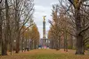 Árboles otoñales del Tiergarten junto a un césped que lleva a la dorada Columna de la Victoria