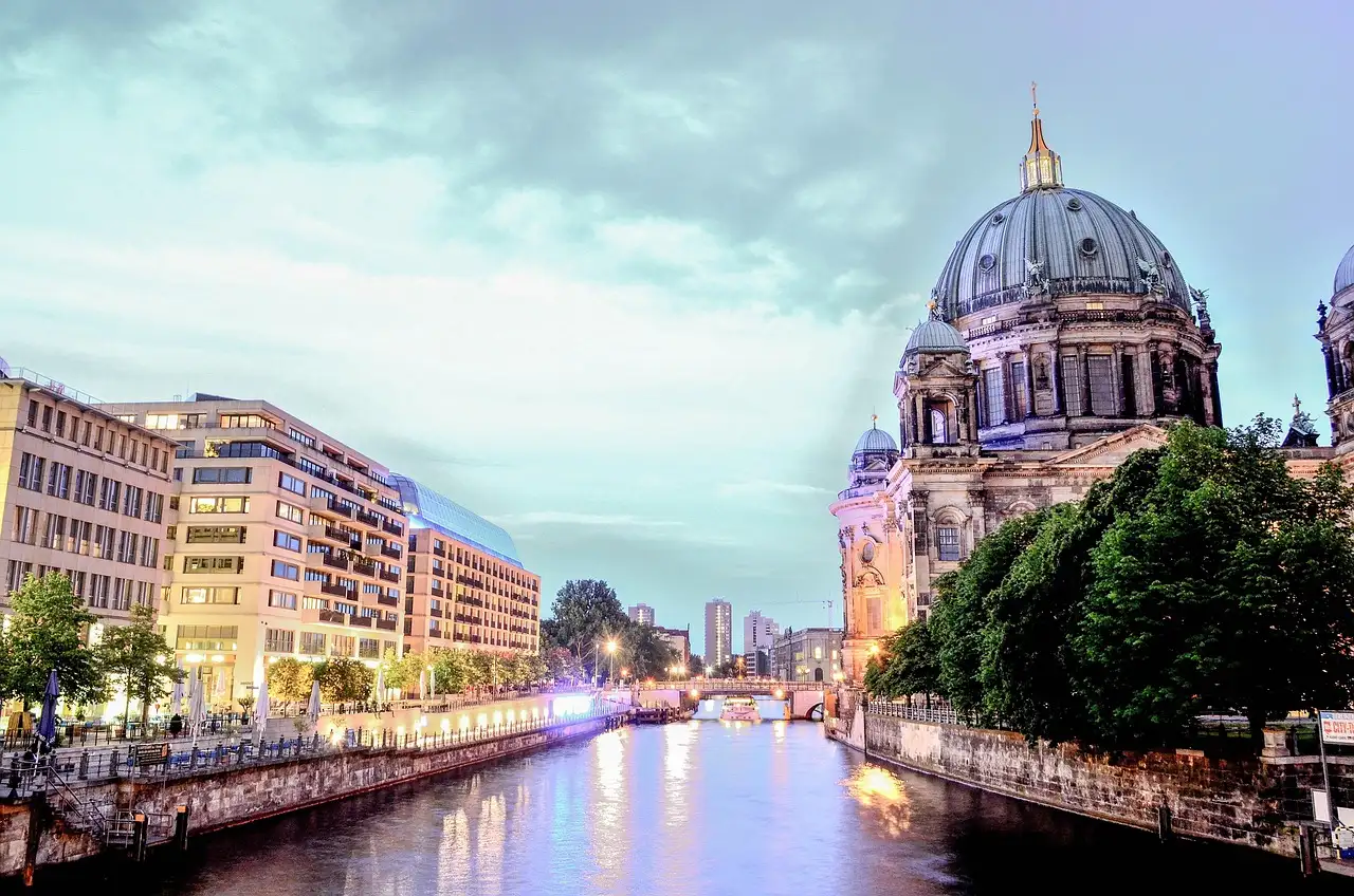 El Spree al anochecer, con edificios iluminados en la orilla y la cúpula de la catedral de Berlín a la derecha