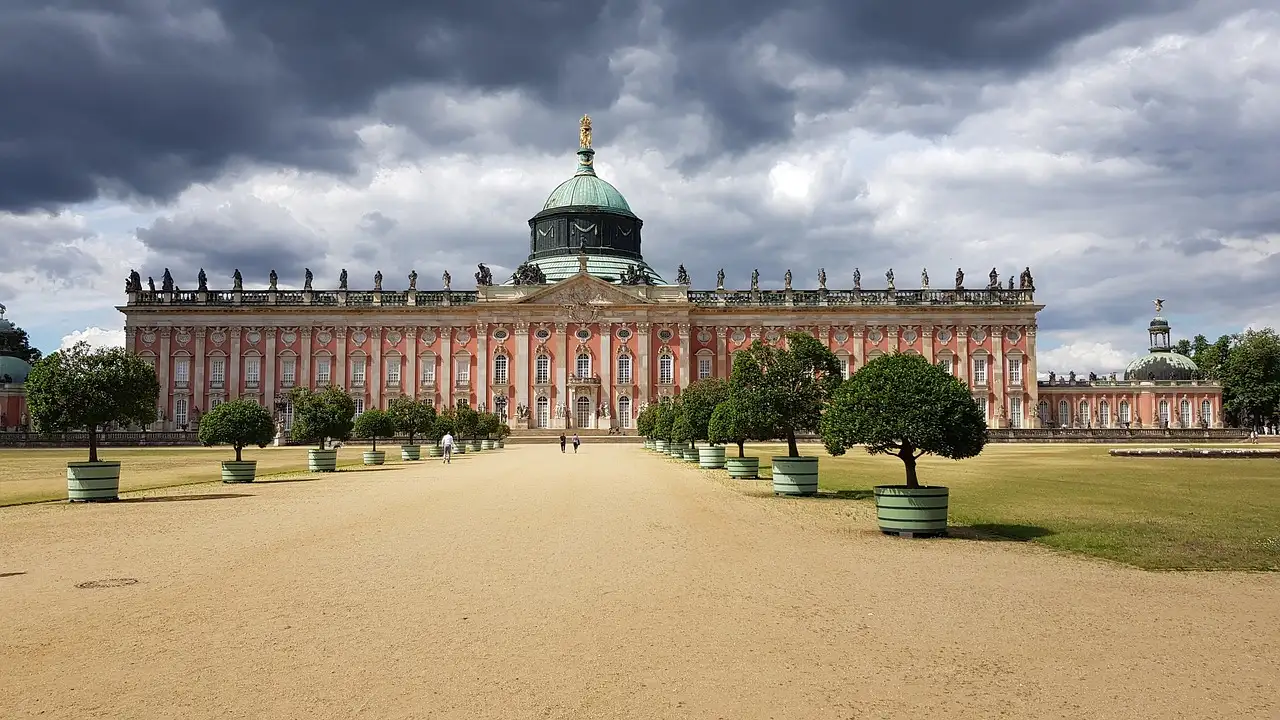 El Palacio Nuevo de Potsdam al final de un ancho camino de grava flanqueado por árboles