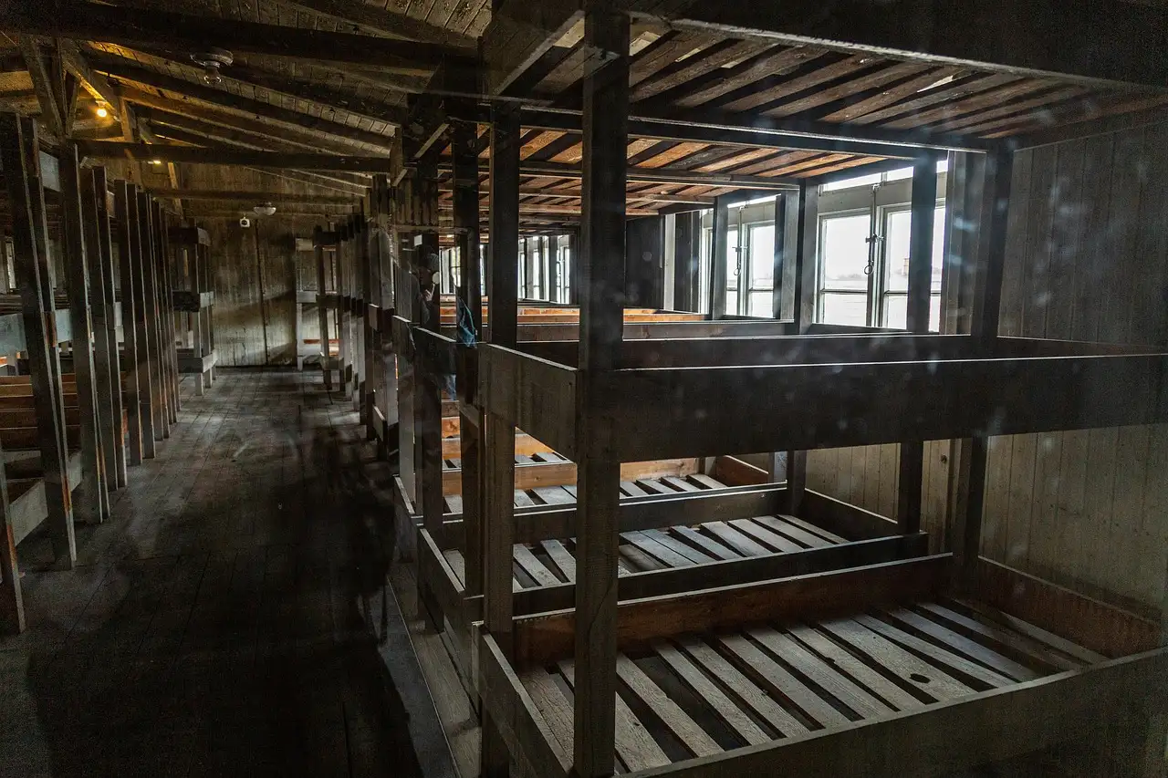 Filas de literas de madera vacías dentro de un barracón del Memorial de Sachsenhausen