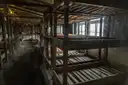 Filas de literas de madera vacías dentro de un barracón del Memorial de Sachsenhausen