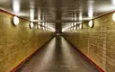 Un túnel vacío del U-Bahn de Berlín, con azulejos amarillos y lámparas redondas