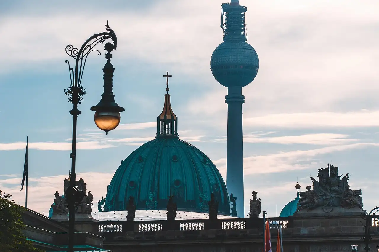 La cúpula verde de la catedral de Berlín y la torre de televisión tras una farola antigua