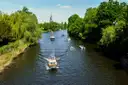 Barcas pequeñas en un tramo verde del Havel en Potsdam, bordeado de árboles